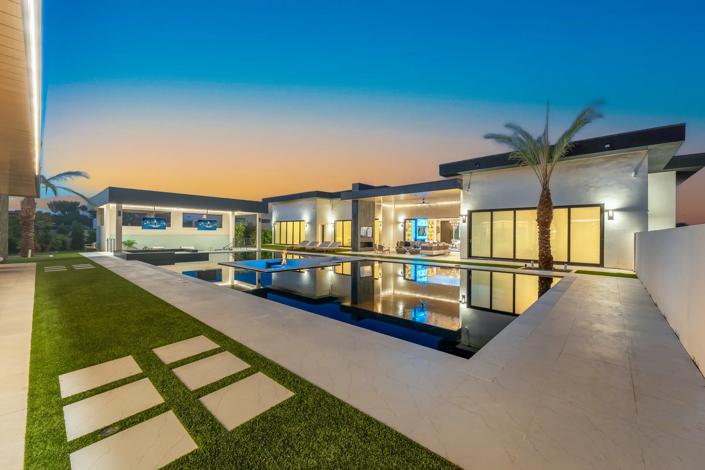Elysium, the flagship Modern Masterpieces estate built by David Widerhorn: reflecting pool and firepit at sunset in Scottsdale, Arizona